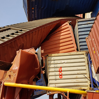 Shipping containers which have been partially crushed. 
